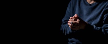 İsa 'nın elini tutan kadın karanlık arka planda dua ediyor. Dişi Hristiyanlar Tanrı 'ya inançla taparlar. Hıristiyan kız meditasyonu ve İsa adına dua. Hıristiyanlık dini kavramı.