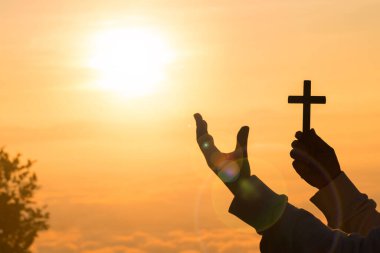 Dua eden kadının silueti sabah Tanrı 'ya ibadet eder, gökyüzünün doğuşuyla birlikte. Hristiyan dini kavramı. İnsan elleri avuçlarını açıp ibadete başlar. Tanrı, Katolik paskalya dualarına tövbe etmesine yardım eder..