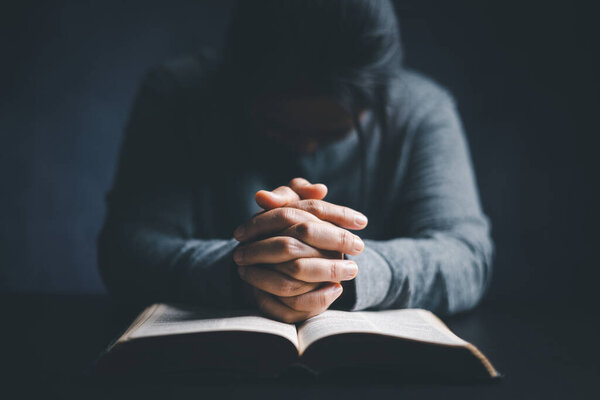 Christian life crisis prayer to god. Woman worship for god blessing to wishing have a better life. woman hands praying to god with the bible. begging for forgiveness and believe in goodness.