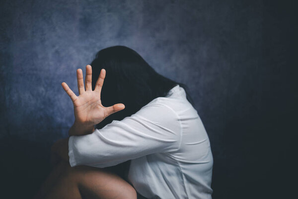 Stop violence against Women, international women's day. Young depressed woman, domestic and rape violence,beaten and raped sitting in the corner.