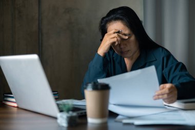 Stresli iş kadını. Yorgun iş kadını uzun süre masa başında oturmaktan sıkılmış ve uykulu ve ofis sendromu var. Ofisteki sıkıcı kadın bilgisayarla çalışıyor ve bilgisayar ekranına bakıyor.