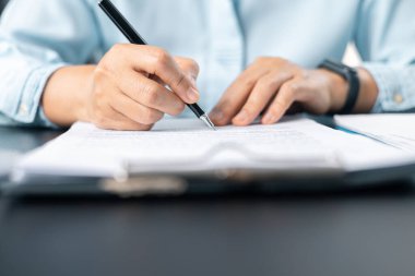 Belgeleri imzalayan iş kadınını kapatın. Kadının eli ofis masasında iş evrakları yazıyor. Belgeyi imzalayan kadın, elinde kalem tutan kadına odaklan, resmi kağıda imza at..