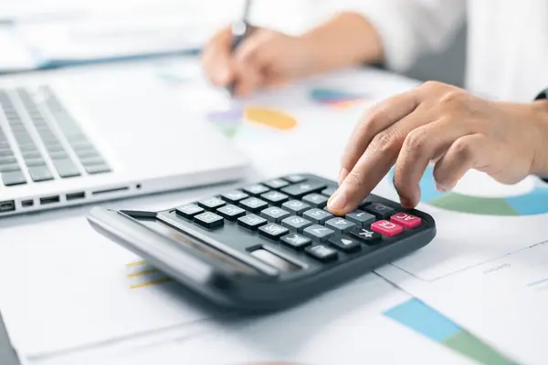 Business financing accounting banking concept. Businesswoman hand doing finances and calculate on desk about cost at home office. Woman working on desk with using calculator, finance accounting.