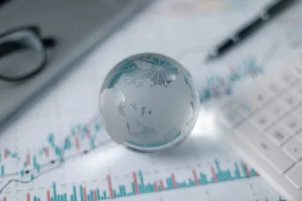 Stock market graphs and data with globe. Glass globe with stock charts, calculator and spectacles, Accounting Concept. Financial accounting stock market graphs analysis.