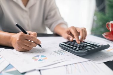 Resepsiyonda çalışan iş kadını hesap makinesi kullanarak rakamları hesaplıyor, muhasebe kavramını finanse ediyor. Kadın muhasebeci hesap makinesi ve bilgisayar kullanıyor. vergi, muhasebe, istatistik