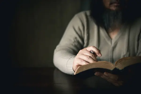 Man with holy bible in his hand, ready to pray, seek guidance from God through religious prayer. Person man, turned to God in prayer, demonstrating their religious faith and devotion through worship.