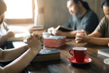 Hıristiyan kadın, dua ederken grupla el ele tutuşurken İncil 'ini sıkı sıkı tuttu. İnançları onları dini bir bağ ile birleştirdi. Hıristiyan grup dua kavramı.