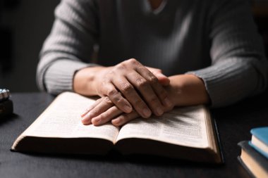 Elinde İncil olan bir kadın, Tanrı 'ya dua ederken ve ona taparken inancı sarsılmaz, Hristiyan dininde güç ve rehberlik bulan kutsal kitap. Dua et, kadın, İncil, inanç, din.