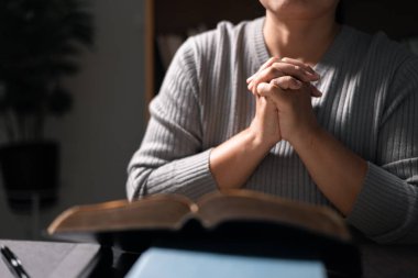 Elinde İncil olan bir kadın, Tanrı 'ya dua ederken ve ona taparken inancı sarsılmaz, Hristiyan dininde güç ve rehberlik bulan kutsal kitap. Dua et, kadın, İncil, inanç, din.