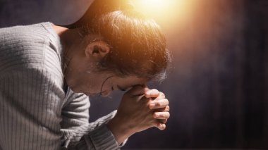 Kadın dua ederken ellerini sıktı, inanç ve umutla, İsa Mesih 'e inanarak, ve Hristiyan dininin ruhuyla Tanrı' nın kutsal varlığını arayarak. Dua et, kadın..