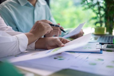 İş toplantısı sırasında yeşil bina performans ölçümleri analiz ediliyor. veri analizi, yeşil bina, iş toplantısı, sürdürülebilirlik, performans ölçümleri, grafikler, emlak, çevre dostu.