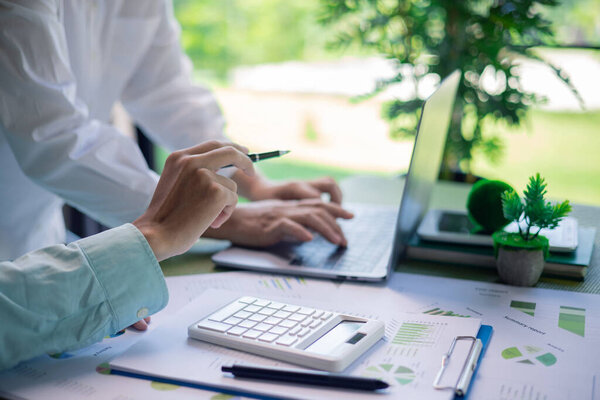 Reviewing sustainability reports and environmental performance charts in business meeting. sustainability reports, environmental performance, business meeting, green building, data analysis, charts.