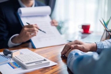 İş kadını mortgage belgesini gözden geçirirken ve müşterileriyle sözleşme imzalarken, kredi ve kredi detaylarını kesinleştirirken, emlak sigortası ve diğer finans yönlerini de tartıştı. finans, kredi, ödeme.