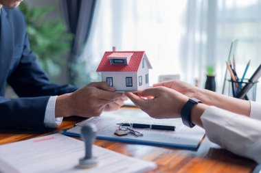 Businessperson yeni bir ev satın almaya, emlak için kredi almaya ve ev sigortası yaptırmaya, emlakçının da satışı kolaylaştırıp ev anahtarını vermeye karar verdi. sigorta, emlak.