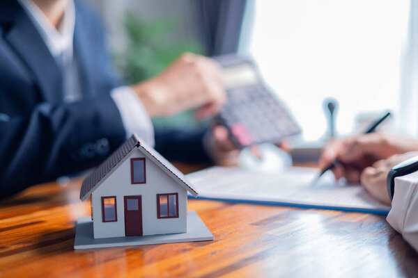 Businessperson decided to buy new home, securing loan to finance property and obtaining insurance for house, with the real estate agent facilitating sale and handing over home key. insurance, estate.