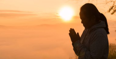 Hristiyan kadın, Tanrı 'ya ibadet etmek ve dua etmek için elini kaldırdı. Huzurlu bir gündoğumu sabahı boyunca İsa Mesih aracılığıyla huzur bulmak için. İbadet, Hıristiyan, İsa Mesih, el, Tanrı, barış, dua, gün doğumu.
