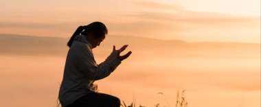 Hristiyan kadın, Tanrı 'ya ibadet etmek ve dua etmek için elini kaldırdı. Huzurlu bir gündoğumu sabahı boyunca İsa Mesih aracılığıyla huzur bulmak için. İbadet, Hıristiyan, İsa Mesih, el, Tanrı, barış, dua, gün doğumu.