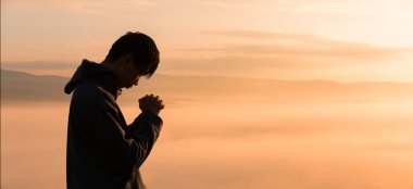 Silüet içinde Hristiyan bir adam, gün batımından gün batımına kadar huzur ve yansıma arayarak Tanrı 'ya dua ediyor ve İsa Mesih' e tapıyor. İsa, İsa, İsa, İsa, İsa, günbatımı, insan, Tanrı, dua.