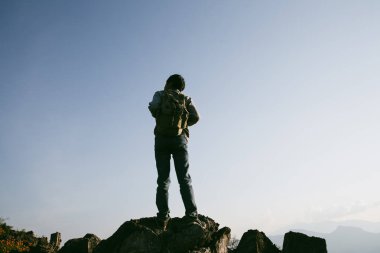 Kameralı gezgin, sırt çantalı, doğa yürüyüşü, seyahat yaşam tarzı ve macera konsepti. Yeşil dağ turu, doğanın güzelliği ve turizmin geniş gökyüzü insanları için turistlere katılın.