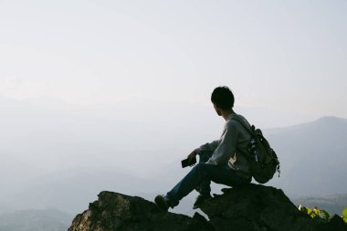 Kameralı gezgin, sırt çantalı, doğa yürüyüşü, seyahat yaşam tarzı ve macera konsepti. Yeşil dağ turu, doğanın güzelliği ve turizmin geniş gökyüzü insanları için turistlere katılın.