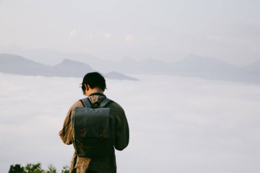 Kameralı gezgin, sırt çantalı, doğa yürüyüşü, seyahat yaşam tarzı ve macera konsepti. Yeşil dağ turu, doğanın güzelliği ve turizmin geniş gökyüzü insanları için turistlere katılın.