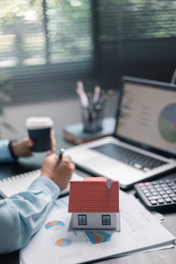 Finans bankası vergisi, muhasebe, bütçe, iş giderleri analizi için işadamı evi. Tasarruf için Finansal hesaplama, muhasebeci, hesap makinesini kapat. Grafik çizelgesi, el yazısı, ofis masası.