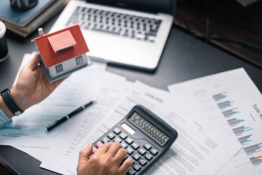 Finans bankası vergisi, muhasebe, bütçe, iş giderleri analizi için işadamı evi. Tasarruf için Finansal hesaplama, muhasebeci, hesap makinesini kapat. Grafik çizelgesi, el yazısı, ofis masası.