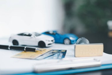 Araba anahtarı, lastik damga ve hesap makinesi konseptiyle onaylanmış araba kredisi başvurusu. Tahta masadaki mali belge. Araba almak için mal varlığı onaylı alışverişler. Araba satın alma listesi vergisi fikirleri