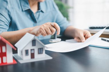 İş kadını el damgası finansal işletme onaylı belge kağıdını onaylıyor. Erkek eli, izin sözleşmesini kabul eder. Komisyoncu yönetici sözleşme banka teminatı onaylı pul başvuru formu imzaladı