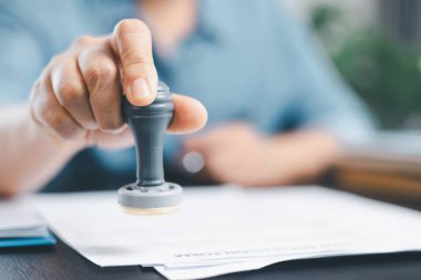 Finans şirketinin onay belgesinde işadamı imzası var. Erkek eli, izin sözleşmesini kabul etti. Komisyoncu yönetici sözleşme banka teminatı onaylı pul başvuru formu imzaladı