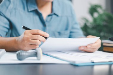 Finans şirketinin onay belgesinde işadamı imzası var. Erkek eli, izin sözleşmesini kabul etti. Komisyoncu yönetici sözleşme banka teminatı onaylı pul başvuru formu imzaladı