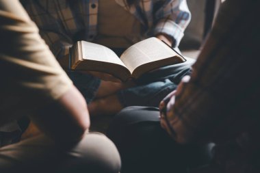 Hristiyanların eli yakın, Katolik kilisesinde kutsal İncil 'e ruhani inançla dua ediyor. Din ibadeti, Tanrı 'dan merhamet dileyin. Hıristiyanlık dini ibadeti.