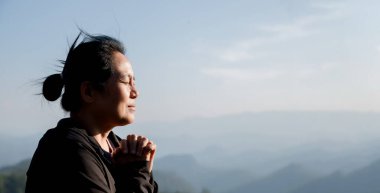 Minnettar bir kadın Tanrı 'ya dua ediyor. Ruhani kız gökyüzüne gülümsüyor. Mutlu bir kadın şükran duyuyor. Ruhsal kız umutla dua ediyor. Pozitif Asyalı genç bir kadın umut ve inanç hissediyor..
