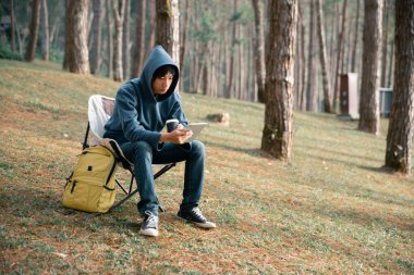 Uzaktan kumanda teknolojisi çevrimiçi iletişim akıllı telefon dizüstü bilgisayar dijital seyahat güneş ışığı kampı içeceği sabah kahve çadırı turuncu dış konsept arka plan iç.