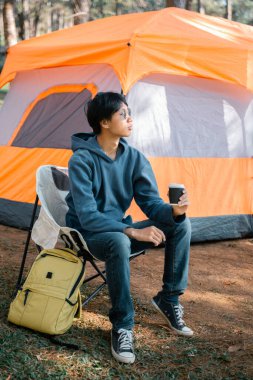 Kafe, kahveyi doğayla uyum içinde yetiştirmeye organik tohum sıcak fincan kafein ve arka plan yeşili açık havaya odaklanıyor. aromatik içecek, bardaktan yükselen zengin aroma.