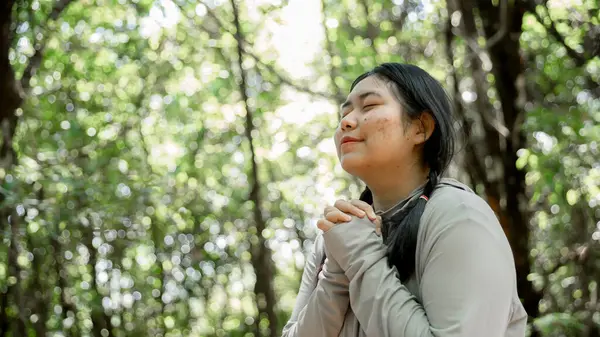 Minnettar bir kadın Tanrı 'ya dua ediyor. Ruhani kız gökyüzüne gülümsüyor. Mutlu bir kadın şükran duyuyor. Ruhsal kız umutla dua ediyor. Pozitif Asyalı genç bir kadın umut ve inanç hissediyor..