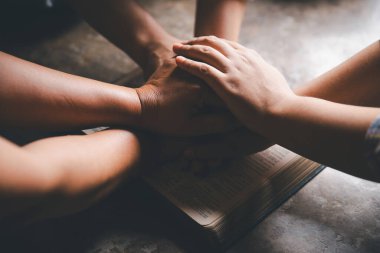 Hristiyanların eli yakın, Katolik kilisesinde kutsal İncil 'e ruhani inançla dua ediyor. Din ibadeti, Tanrı 'dan merhamet dileyin. Hıristiyanlık dini ibadeti.