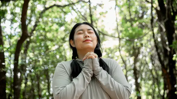 Minnettar bir kadın Tanrı 'ya dua ediyor. Ruhani kız gökyüzüne gülümsüyor. Mutlu bir kadın şükran duyuyor. Ruhsal kız umutla dua ediyor. Pozitif Asyalı genç bir kadın umut ve inanç hissediyor..