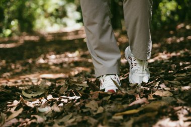 Dağ çim patikasında yürüyüş. Kadın yürüyüşçü ayakkabısını kapat. Yürüyüşçülerin ve sırt çantalarının maceraperest yaşam tarzı seyahat ve dağ yürüyüşleri, her yürüyüşün ve heyecanlı yolculuğun her bölümünün tadını çıkar.