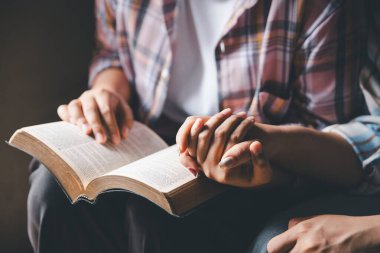 Hristiyanların eli yakın, Katolik kilisesinde kutsal İncil 'e ruhani inançla dua ediyor. Din ibadeti, Tanrı 'dan merhamet dileyin. Hıristiyanlık dini ibadeti.