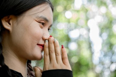 Minnettar bir kadın Tanrı 'ya dua ediyor. Ruhani kız gökyüzüne gülümsüyor. Mutlu bir kadın şükran duyuyor. Ruhsal kız umutla dua ediyor. Pozitif Asyalı genç bir kadın umut ve inanç hissediyor..