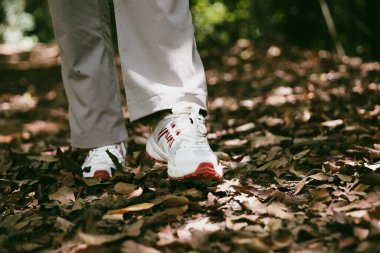 Dağ çim patikasında yürüyüş. Kadın yürüyüşçü ayakkabısını kapat. Yürüyüşçülerin ve sırt çantalarının maceraperest yaşam tarzı seyahat ve dağ yürüyüşleri, her yürüyüşün ve heyecanlı yolculuğun her bölümünün tadını çıkar.