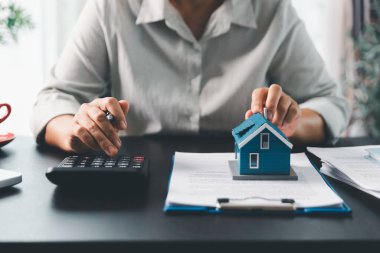 Emlakçı, müşteri temsilciliğine ev almayı kabul etti. Ev modeli, emlakçı, ev, sigorta, kredi emlak geçmişi için kontrat imzalamak isteyen müşteri. Kavram anlaşması.