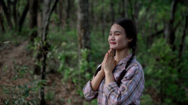 Minnettar bir kadın Tanrı 'ya dua ediyor. Ruhani kız gökyüzüne gülümsüyor. Mutlu bir kadın şükran duyuyor. Ruhsal kız umutla dua ediyor. Pozitif Asyalı genç bir kadın umut ve inanç hissediyor..