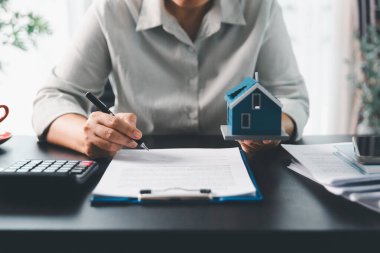 Emlakçı, müşteri temsilciliğine ev almayı kabul etti. Ev modeli, emlakçı, ev, sigorta, kredi emlak geçmişi için kontrat imzalamak isteyen müşteri. Kavram anlaşması.