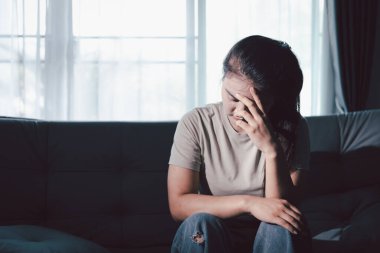 Boş karanlık odada kederli bir adam, elleri ile yüzünü kapatan depresif genç bir kadın. Üzüntülü yüzüyle başa çıkan genç bir kadın. Akıl sağlığı konsepti. Sıkıcı üzgün sinirli sinirli.