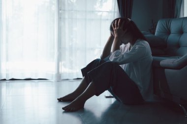 Evdeki kanepede oturan umutsuz, yorgun kız. Genç kadın oturma odasında oturuyor, üzgün ve depresif hissediyor. Psikolojik bir sorun. Depresyon ve yalnızlık kavramı.