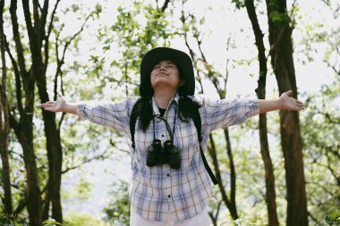 Sırt çantalı genç bir gezgin ulusal parkta ya da ormanda yürüyor. Doğada eğlence sporu. Kadın çantası, ormanda yürüyüş için el sallıyor. Ormanda macera. Sırt çantasıyla yürüyüş