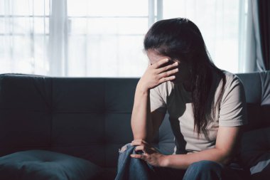 Boş karanlık odada kederli bir adam, elleri ile yüzünü kapatan depresif genç bir kadın. Üzüntülü yüzüyle başa çıkan genç bir kadın. Akıl sağlığı konsepti. Sıkıcı üzgün sinirli sinirli.