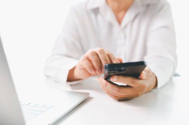 Yakın plan iş kadını ofis masasında akıllı cep telefonu kullanıyor, kız öğrenci evde online e-öğrenim okuyor, internette bilgi arıyor, sosyal ağlara bağlanıyor.